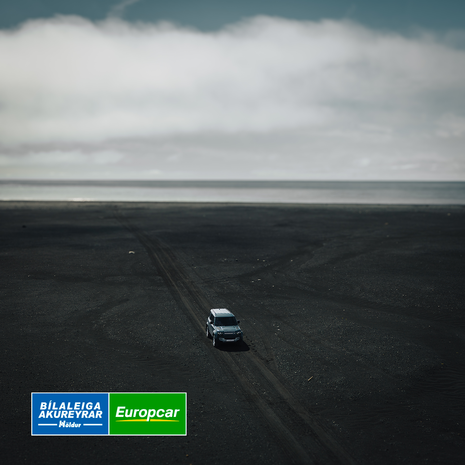 Landrover Defender driving on black sand beach in Iceland