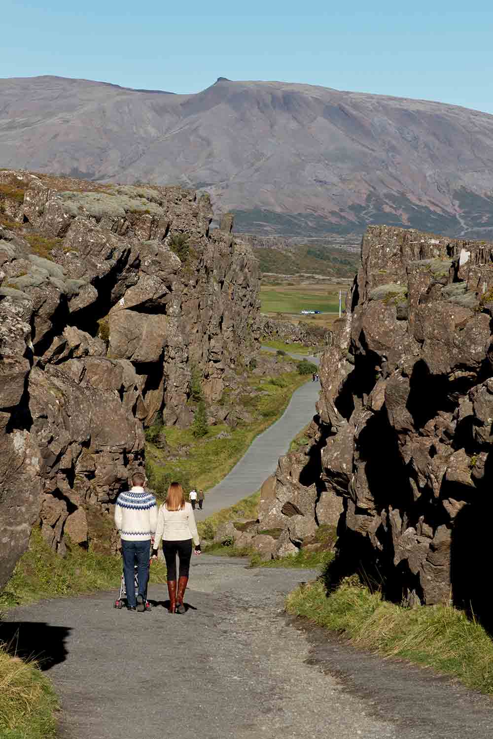 Couple with child in a cart walking in Thingvellir national park